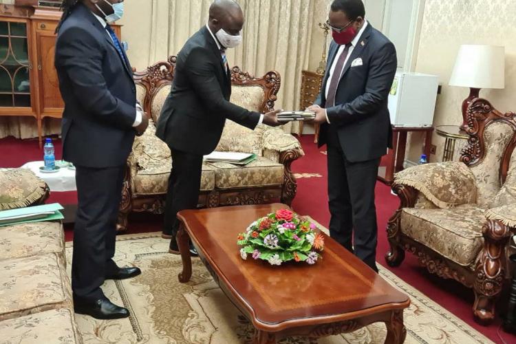 The director Masauko Chamkakala presents a gift to his excellency Dr. Lazurus Chakwera whilst his deputy Trouble Kalua looks on