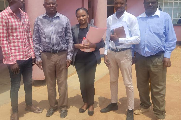 Lanjeni Banda (in blue checkered shirt) posing with Legal Aid Bureau counsel